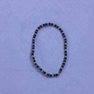 a cute small beaded bracelet that is white blue and 2 different colors of brown
